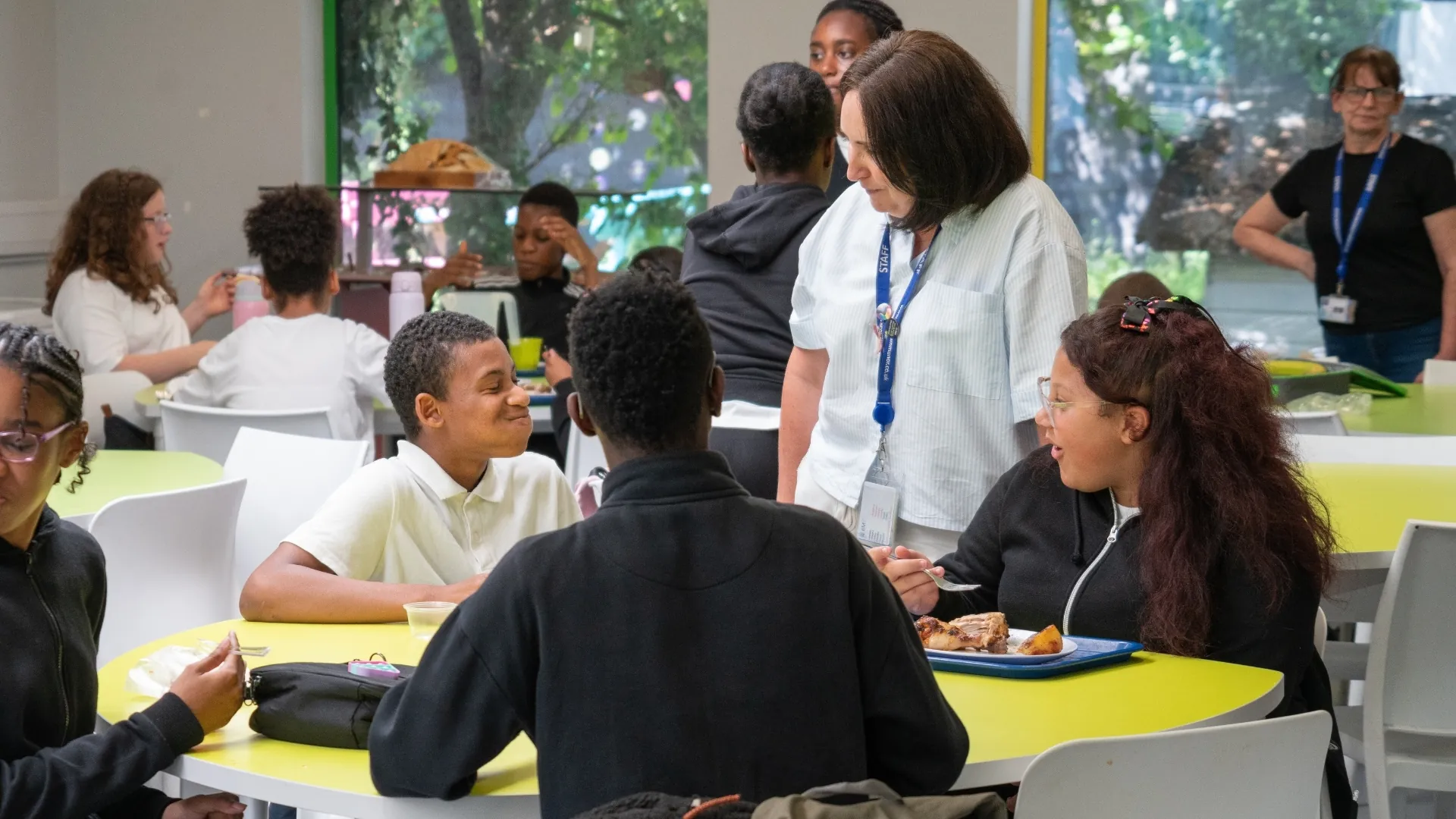 Students eating lunch together at tables in the dining hall.